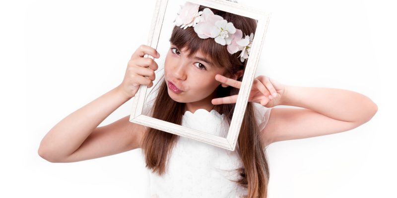Communion girl grimacing with a frame on her face